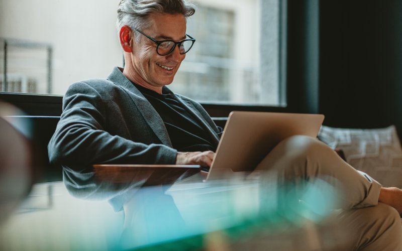 Affärsperson som arbetar på bärbar dator i kontorslobbyn